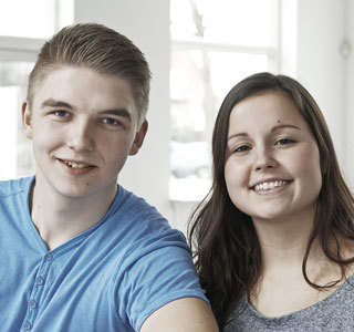 En dreng og en pige som smiler.